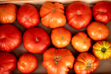 Tasty big ripe french tomatoes in wooden boxes on farmers market in Provence