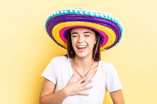 young hispanic woman laughing out loud at some hilarious joke. mexican hat concept
