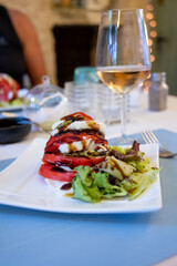 Big red french tomato served with fresh mozzarella cheese, basil pesto and creme balsamico as starter in restaurant in Provence, France