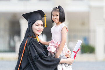 Woman Graduate with Little Girl on her Graduation Day.