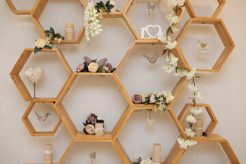 Fragement of interior decoration. Wall with wooden honeycomb shelves. Trendy design.