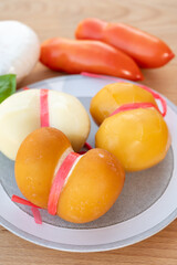 Cheese collection, variety of Italian cow milk cheese scamorza with Italian houses on background