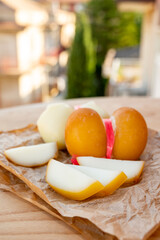 Cheese collection, variety of Italian cow milk cheese scamorza with Italian houses on background