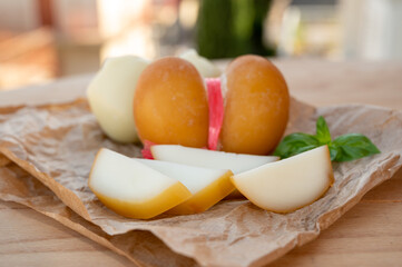 Cheese collection, variety of Italian cow milk cheese scamorza with Italian houses on background