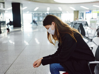 woman with closed eyes in medical mask sitting at the airport waiting for a long time