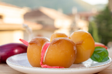 Cheese collection, yellow smoked Italian cow milk cheese scamorza with Italian houses on background
