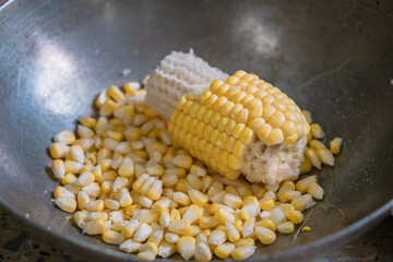 Fresh Sweet Corn Grains separating from the corncob .
