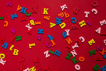 Random colorful alphabet on a red background, colorful letters.