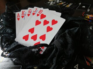 Cork - September 2, 2021: Picture of a "Royal Flush" poker hand placed on black lace with black and white playing cards in the background as part of my Poker Meets Panache photoshoot
