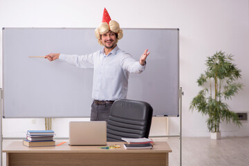 Funny young male teacher magician in the classroom