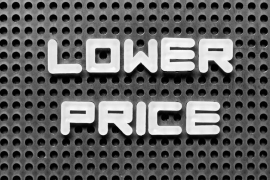 White alphabet letter in word lower price on black pegboard background