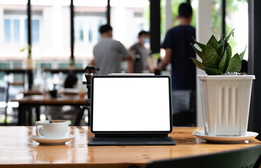 Shot of blank screen tablet with keyboard on wooden desk in office
