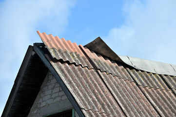 Fototapeta na wymiar Damaged slate roof piece on a pitched roof