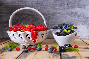 full bowls of ripe berries - blueberries, currants and blackberries
