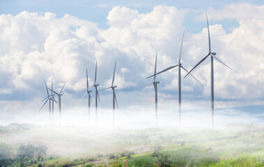 Wind turbines for generate electricity clean energy, on the land field with sea of fog and clouds on the morning.
