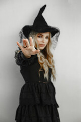 Woman wearing black costume. Lady with halloween makeup. Girl on a white background.