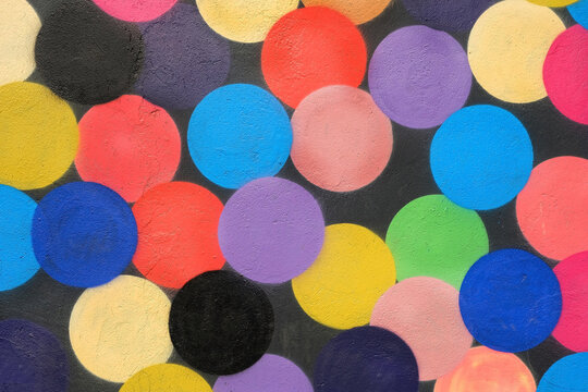 painted colorful dots pattern on stone Wall Texture. Abstract drawing fashion colors on stone wall. Urban creative contemporary culture. temlate for design.