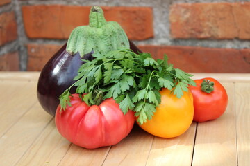 Eggplant, tomatoes and parsley on a wall background. Organic vegetables..