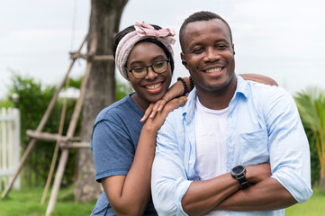 Happy and smiling young African American couple in outdoor garden - sweet and funny lover couple, Family outdoor lifestyle