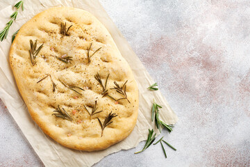 Freshly baked Italian traditional homemade focaccia bread baking with seasonings and rosemary on...