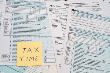 Obraz premium many American tax forms 1040 lie mixed with a piece of paper from a notebook on them