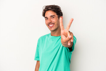 Naklejka premium Young mixed race man isolated on white background joyful and carefree showing a peace symbol with fingers.