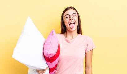 young hispanic woman with cheerful and rebellious attitude, joking and sticking tongue out. pajamas...