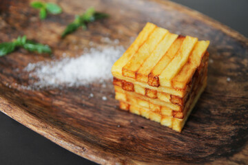 French fries
  on a wooden plate with spices and herbs.