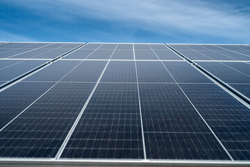 against the background of a beautiful blue sky new clean energy saving solar panels stand.