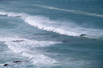 Ocean waves seen from a cliff in north Cornwall in the summer sun.