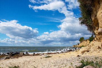 Steilküste Ostsee mit Sandstrand und Findlingen an einem sonnigen Sommertag