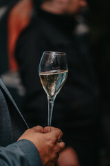 Elegant waiter pours champagne from bottle into glass at restaurant. Sommelier tasting white sparkling wine in restaurant. Copy space for text menu elegant or recipe on dark background.