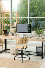 Comfortable workplace with computer in light room. Interior design