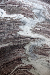 Fototapeta premium Full frame close-up view of a brown and white marbled granite stone surface with a variety of patterns