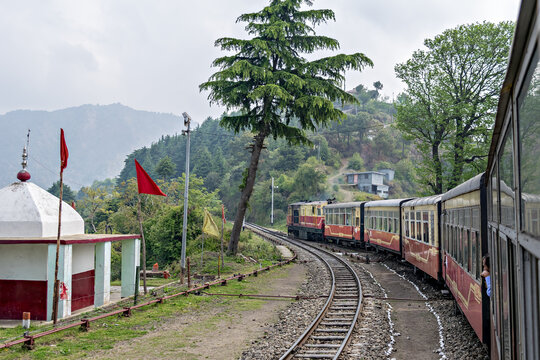 Narrow gauge Shivalik Deluxe express train on curve while departing Shoghi.