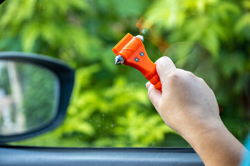 Woman use Safety Hammer and Seatbelt Cutter in Cars, break glass When emergency. In case of...