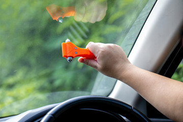 Woman use Safety Hammer and Seatbelt Cutter in Cars, break glass When emergency. In case of...