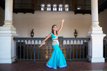 beautiful young belly dancer is posing for the camera in a photo shoot. The woman is beautiful and dressed in traditional clothes. Beauty, folklore and belly dance concept.
