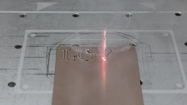 laser installation carves the word love on metal