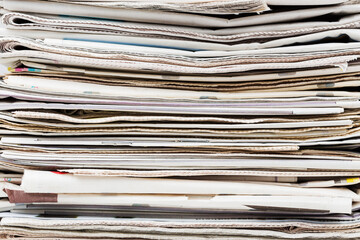 Pile of stacked generic folded newspapers background