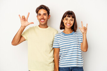 Young mixed race couple isolated on white background showing a horns gesture as a revolution concept.