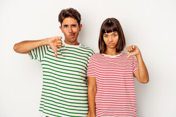 Young mixed race couple isolated on white background showing thumb down, disappointment concept.