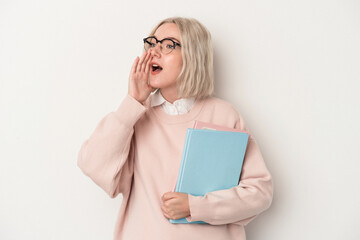 Young caucasian student woman holding books isolated on white background shouting and holding palm near opened mouth.