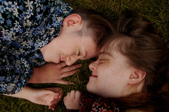 High angle portrait of young couple with Down Syndrome and Foetal Alcohol Syndrome next to each other and smiling
