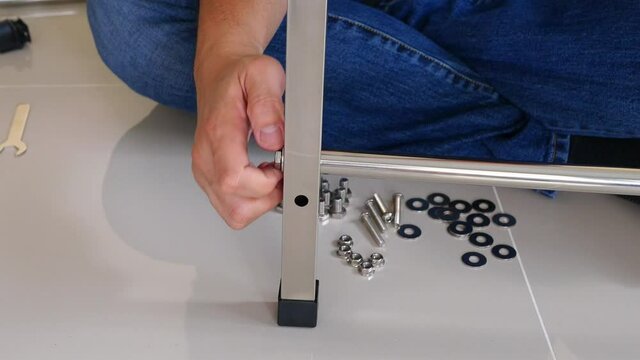 Man doing DIY assembly steel table frame home furniture interia decoration