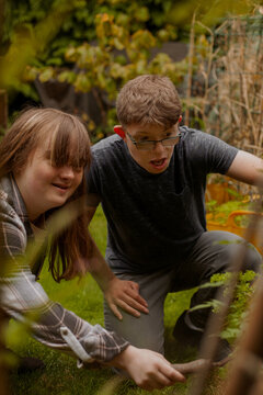 Young couple with Down Syndrome and Foetal Alcohol Syndrome gardening together and having fun