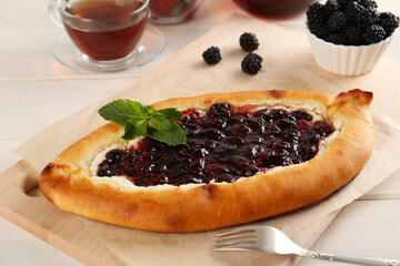 Delicious sweet cottage cheese pastry with cherry jam served on white wooden table