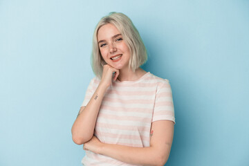 Young caucasian woman isolated on blue background smiling happy and confident, touching chin with hand.