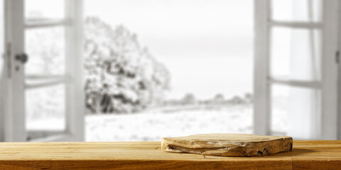 Wooden desk of free space and winter window background. 