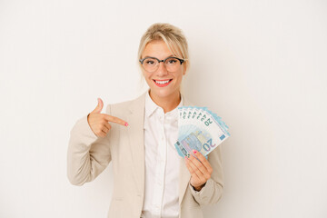 Young business Russian woman holding banknotes isolated on white background person pointing by hand to a shirt copy space, proud and confident